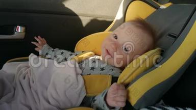一个可爱的小婴儿坐在汽车座椅上，微笑和旅行的快乐。